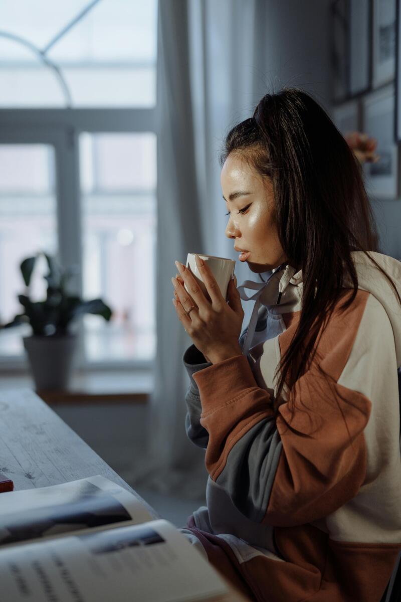 Woman reading journal with morning coffee — confidence and self-growth for women