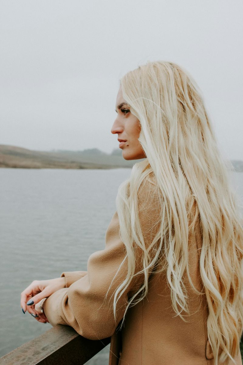 Woman standing by water at sunrise — This Is Her Time self-growth guides for women